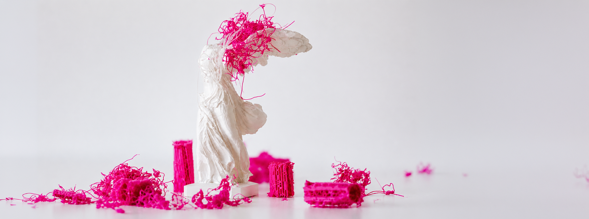Classical sculpture surrounded by vivid pink fragments representing media and technological transformation